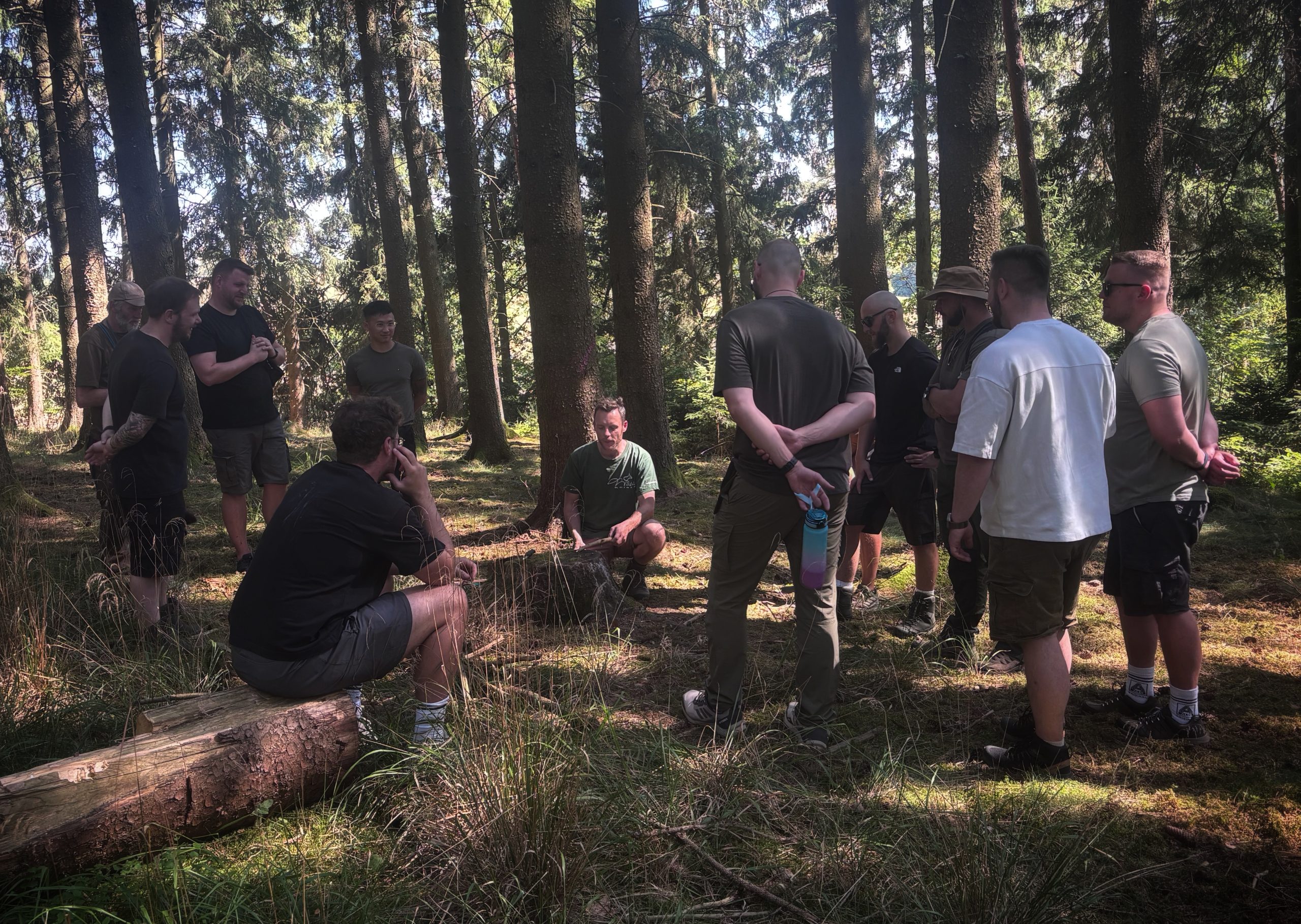 Teilnehmende bei einer angeleiteten Outdoor-Aufgabe im Wald